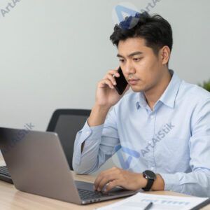 Взрослый мужчина за ноутбуком в офисе.