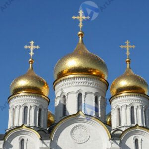 Церковь с золотыми куполами на фоне синего неба.