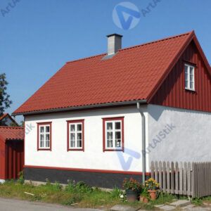 Небольшой домик с красной крышей и белыми стенами в деревне.