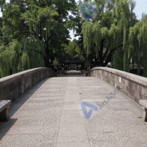 Старинный каменный мост‑здание с лавками по бокам.