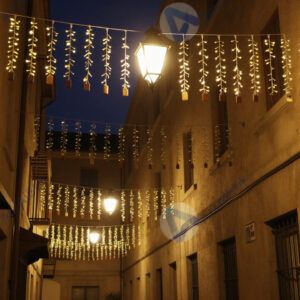 Переулок с уличными фонариками‑гирляндами над головой.