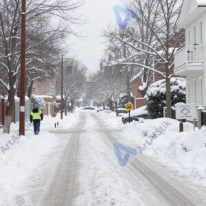 Улица зимой со снежными сугробами и расчищенной дорожкой.