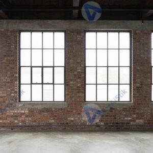 Лофт с кирпичной стеной и большими промышленными окнами.