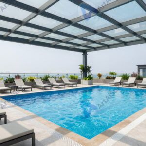 Бассейн под крышей с стеклянным потолком и шезлонгами по краям.