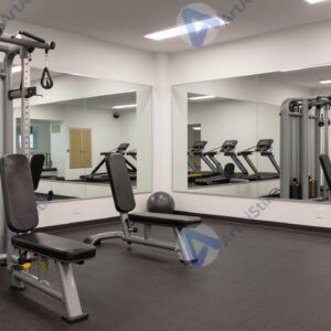 Спортзал с тренажёрами и зеркальной стеной.