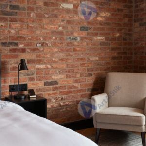 Номер в бутик‑отеле с кирпичной стеной и дизайнерским креслом.
