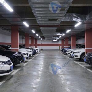 Подземная парковка с рядами машин и колонн.