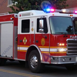 Пожарная машина на улице с включёнными мигалками.