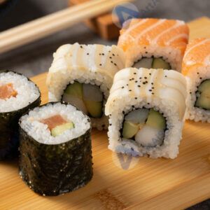 Набор суши и роллов на бамбуковой доске с палочками.