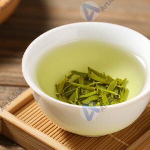 Зелёный чай в фарфоровой чашке на бамбуковой подставке.