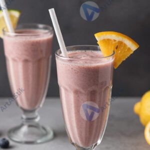 Смузи в высоком стакане с трубочкой и украшением из фруктов.