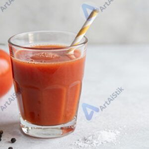 Стакан томатного сока с солью и перцем на столе.