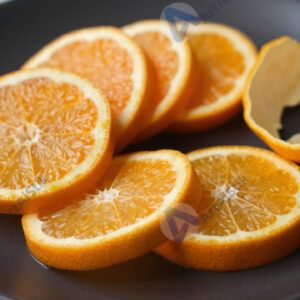 Мандариновые дольки и кожура на чёрной тарелке.