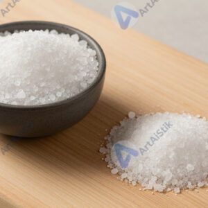 Крупная морская соль в миске и щепотка на доске.