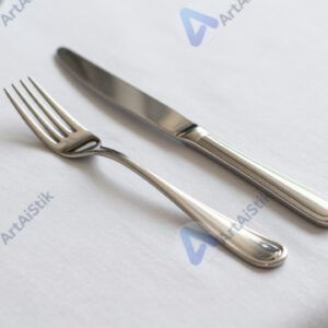 Столовые приборы на белой скатерти.