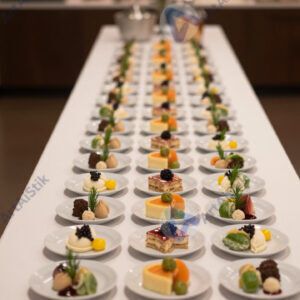 Узкий высокий столик для фуршета с маленькими тарелками.