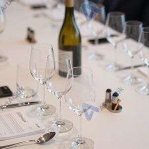 Стол для дегустации вин с рядами бокалов и плевательницами.