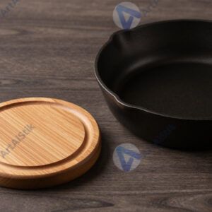 Стол с деревянными подставками под горячее и чугунной сковородой.