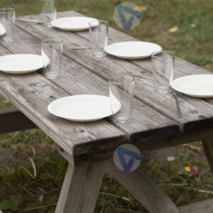 Пикниковый стол из досок с бумажными тарелками и стаканами.