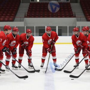 Хоккейная команда выстраивается на вбрасывание в центре поля.