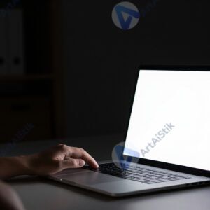 Свет от ноутбука освещает лицо в тёмной комнате.