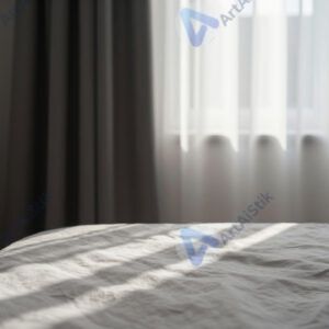 Утренний свет через окно освещает только часть кровати.