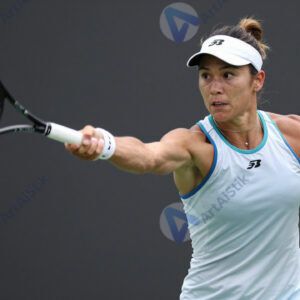 Теннисистка бьёт по мячу с форхенда