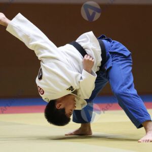 Дзюдоист бросает соперника через бедро на татами.