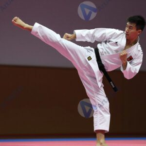 Боец карате наносит удар ногой в воздухе