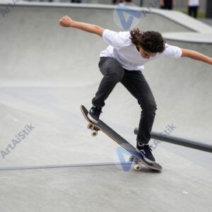 Скейтбордист скользит по периллу (гринд) в скейт‑парке.