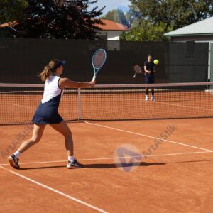 Теннисный мяч летит над сеткой на глинистом корте.