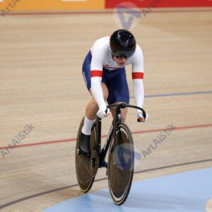 Велосипедист в велодроме наклоняется в вираж.