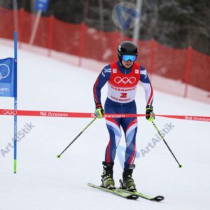 Лыжник с гоночным номером пересекает финишную черту.