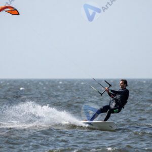 Кайтсерфер в прыжке с кайтом над водой.