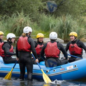 Группа людей в гидрокостюмах готовится к сплаву по реке.