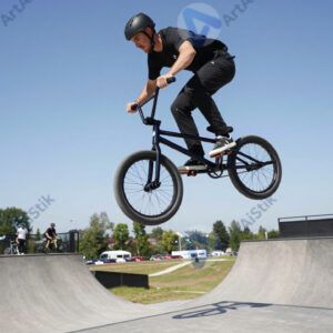 BMX‑райдер крутит барспин над рампой.