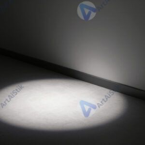 Свет от прожектора создаёт резкую границу между светом и тенью на полу.