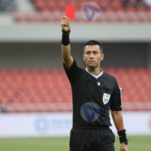 Судья поднимает красную карточку в футбольном матче.