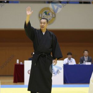 Судья в кимоно поднимает руку