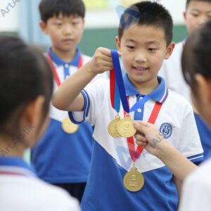 Ребёнок получает медаль на школьных соревнованиях.