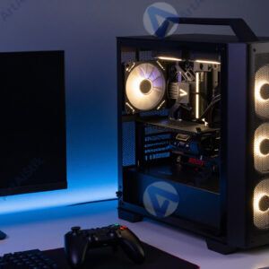 Игровой ПК с подсветкой корпуса и геймпадом на столе.