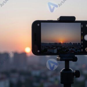 Смартфон на штативе снимает таймлапс заката над городом.