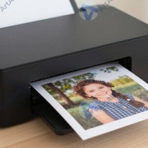 Небольшой фотопринтер печатает только что снятую фотографию.