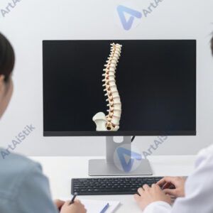 Врач и пациент смотрят на 3D‑модель позвоночника на мониторе.