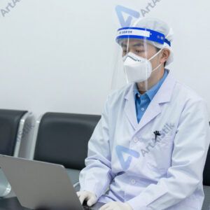 Врач в защитном щитке и респираторе в приёмном покое.