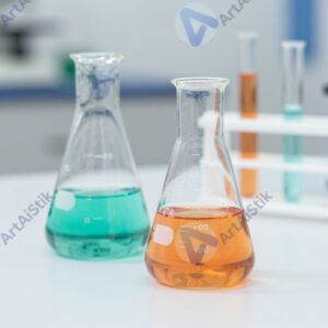 Химические реактивы в цветных колбах на белом столе.