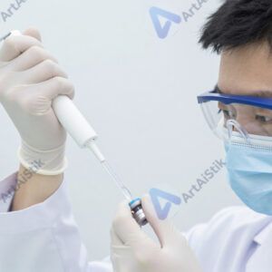 Учёный в защитных очках пипеткой набирает раствор.