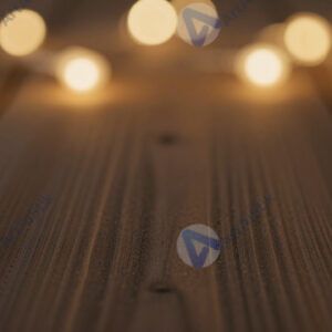 Тёплое золотистое bokeh на фоне тёмного дерева.