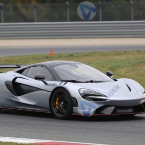 Спортивный автомобиль на гоночной трассе в повороте.