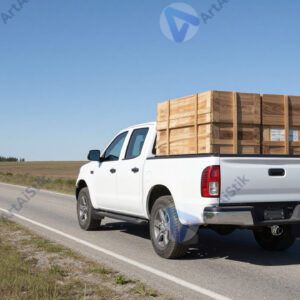 Грузовой пикап с грузом в кузове на просёлочной дороге.